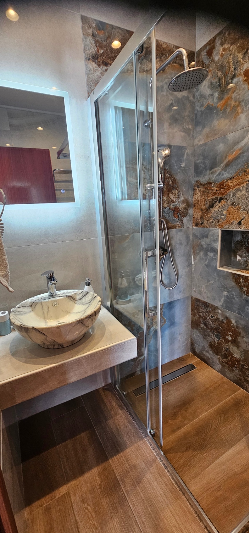 Shower and lit vanity mirror